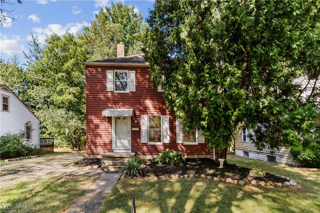 View of front of house featuring a chimney and a front yard