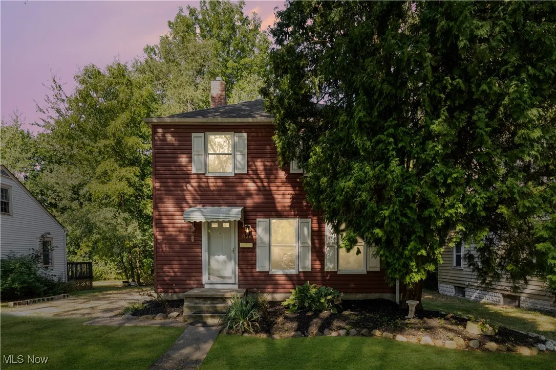 View of front of house with a chimney and a front yard