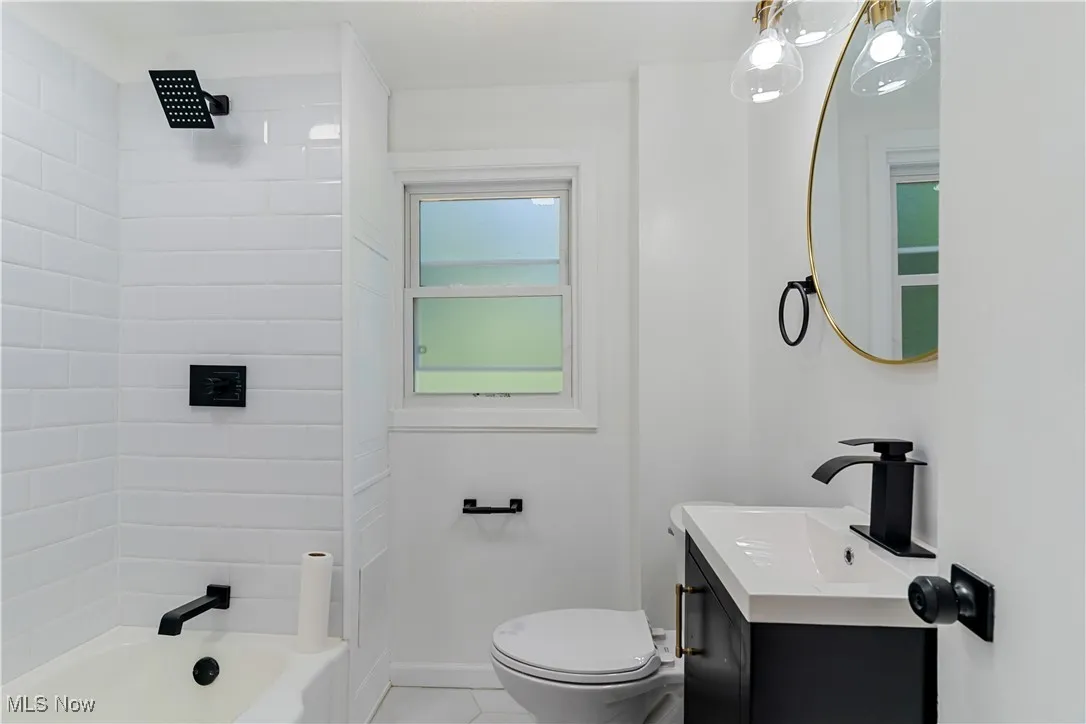 Bathroom with vanity, shower / bathtub combination, and light tile patterned floors