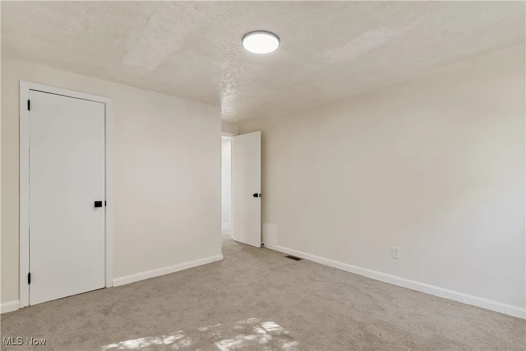 Unfurnished bedroom with a textured ceiling and carpet flooring