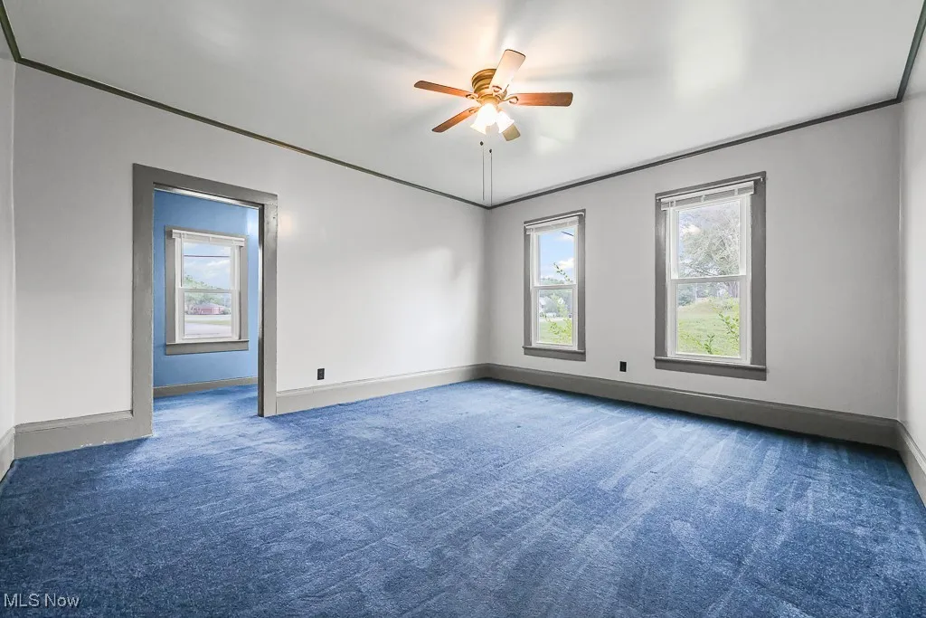  Bedroom with carpet floors, crown molding, and ceiling fan