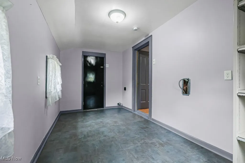 Laundry with baseboards and dark floors