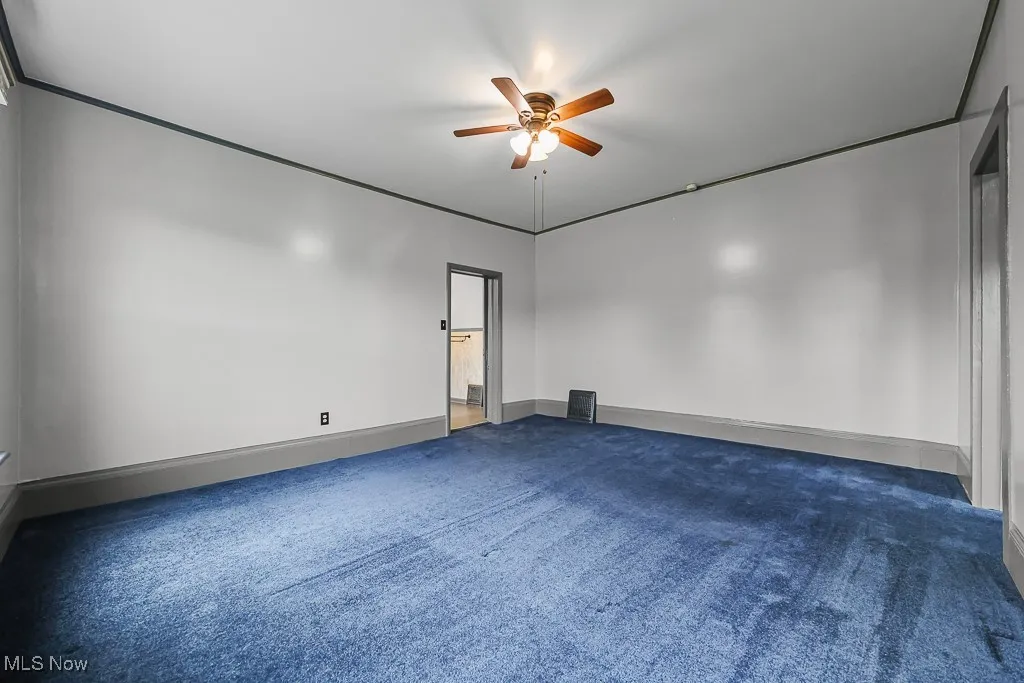 Carpeted bedroom with crown molding and a ceiling fan