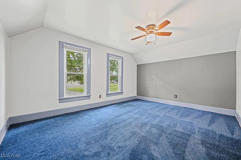 Bedroom with vaulted ceiling, carpet floors, and ceiling fan