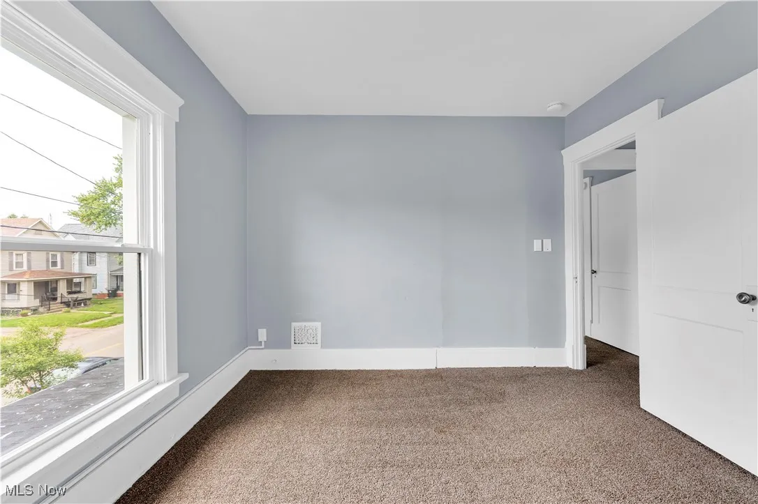 Carpeted empty room featuring baseboards