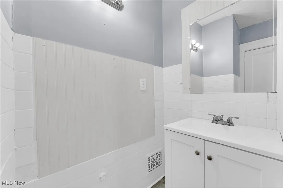 Bathroom with vanity, tile walls, and backsplash