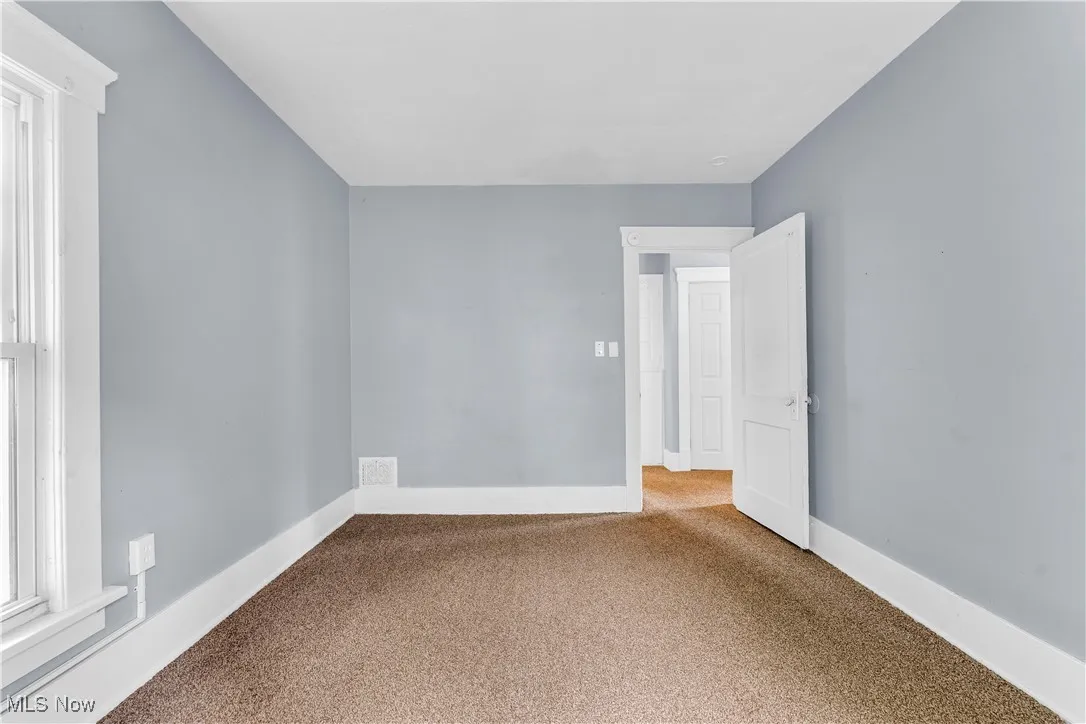 Empty room with carpet flooring and baseboards