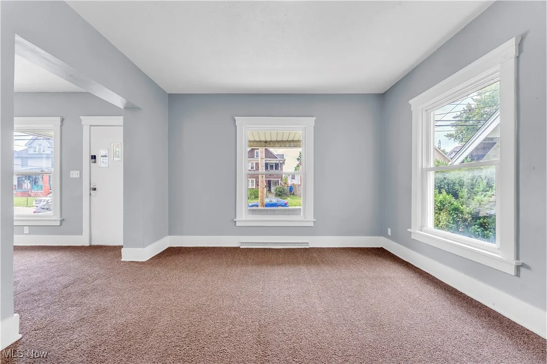 Empty room with carpet and healthy amount of natural light