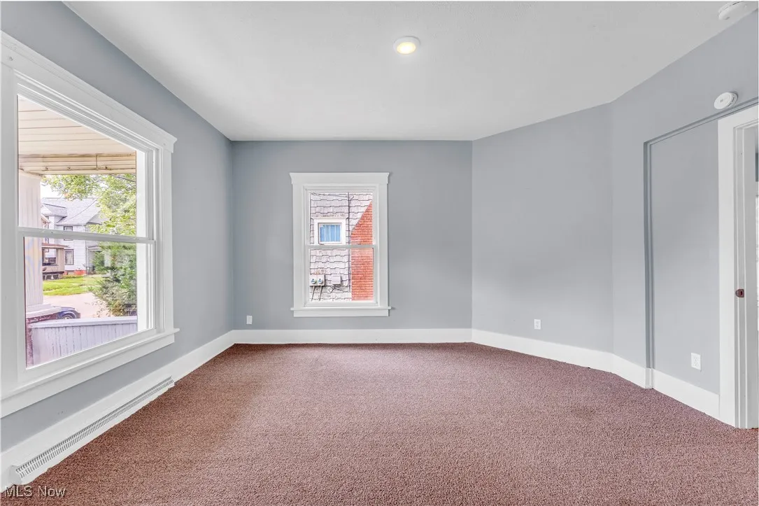 Unfurnished room with carpet flooring and baseboard heating