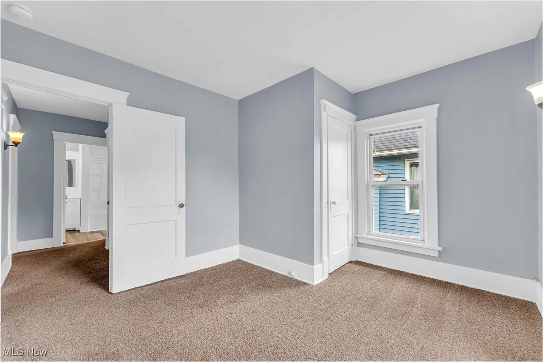 Unfurnished bedroom with carpet floors and baseboards