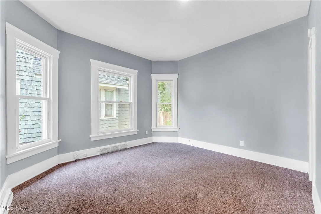 Carpeted empty room with baseboards