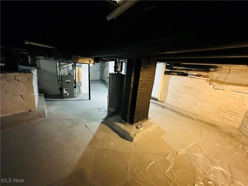 Unfinished basement featuring water heater and heating unit