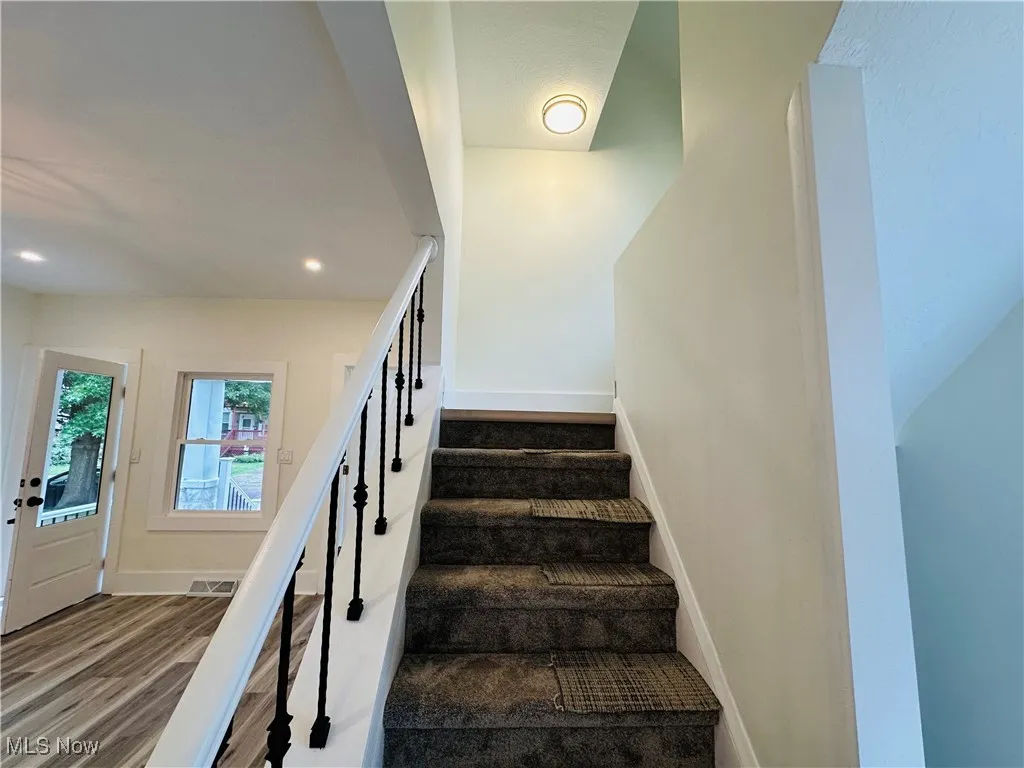 Stairs featuring recessed lighting and wood finished floors