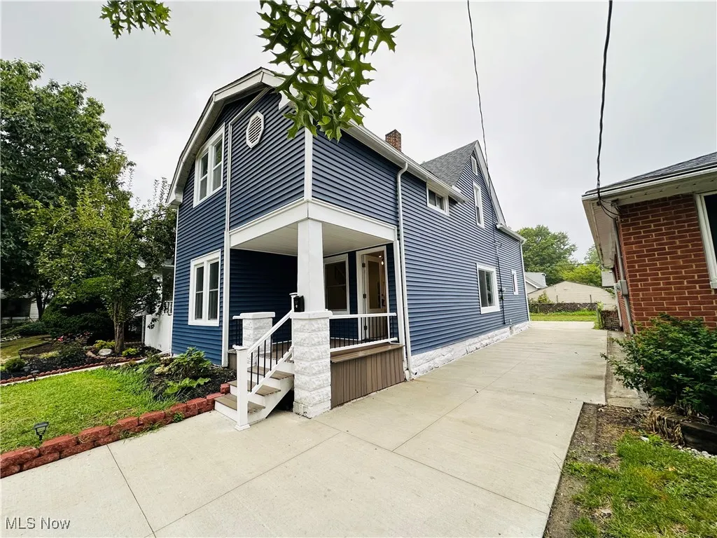 View of front facade featuring a porch and a chimney