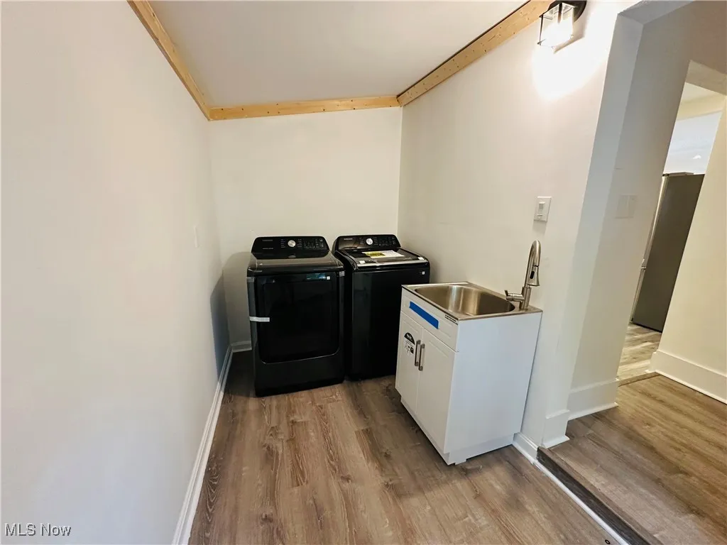 Washroom featuring light wood finished floors and washing machine and clothes dryer