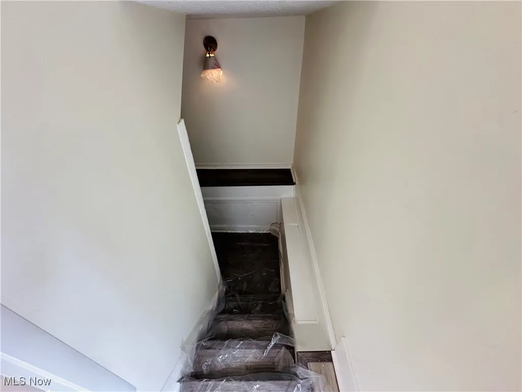 Stairs featuring baseboards and a textured ceiling