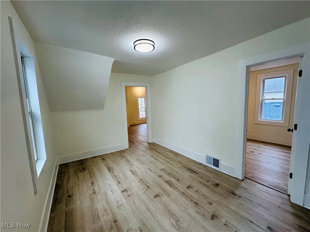 Bonus room featuring a textured ceiling and light wood-type flooring