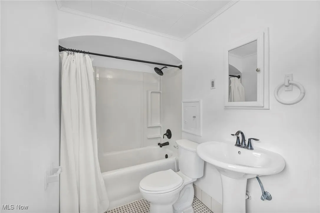 Full bath featuring shower / tub combo, ornamental molding, and tile patterned flooring