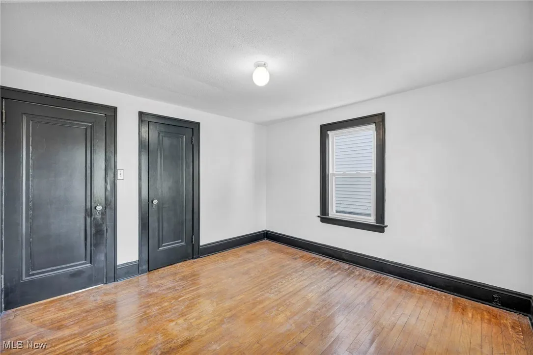 Unfurnished room featuring wood-type flooring and a textured ceiling