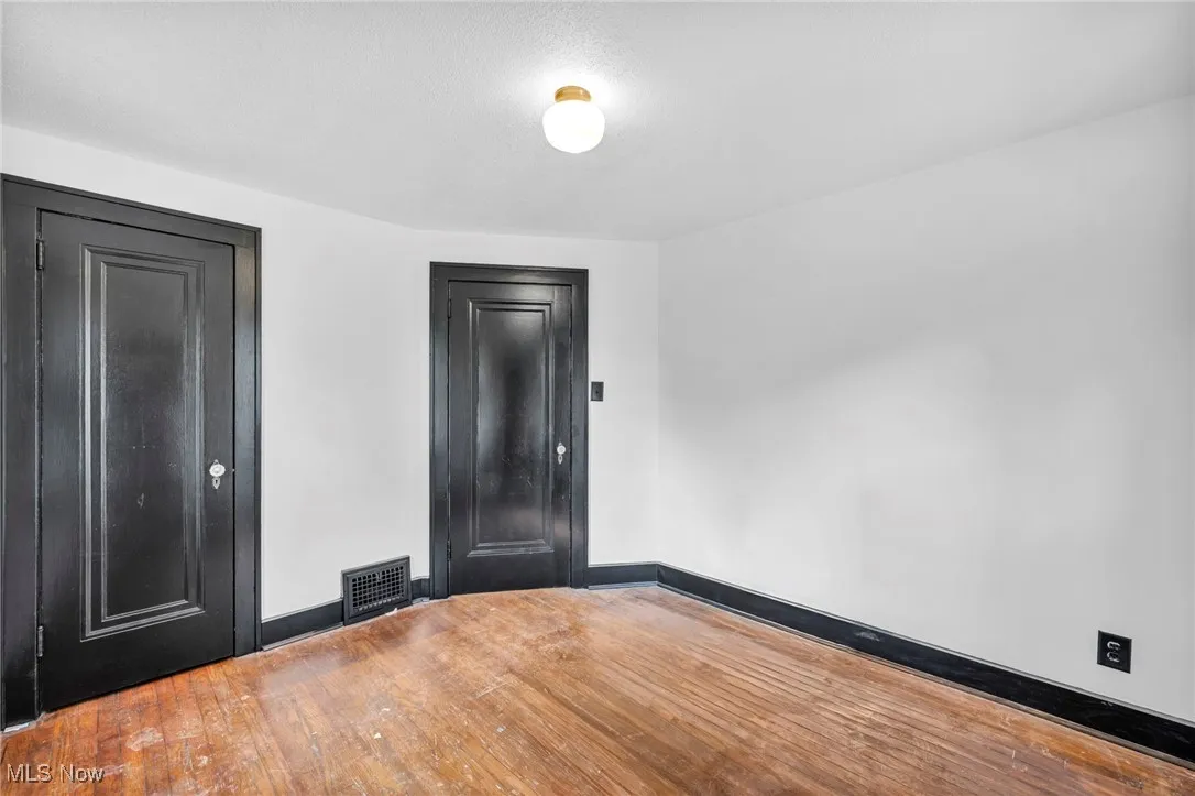 Empty room with hardwood / wood-style floors and baseboards