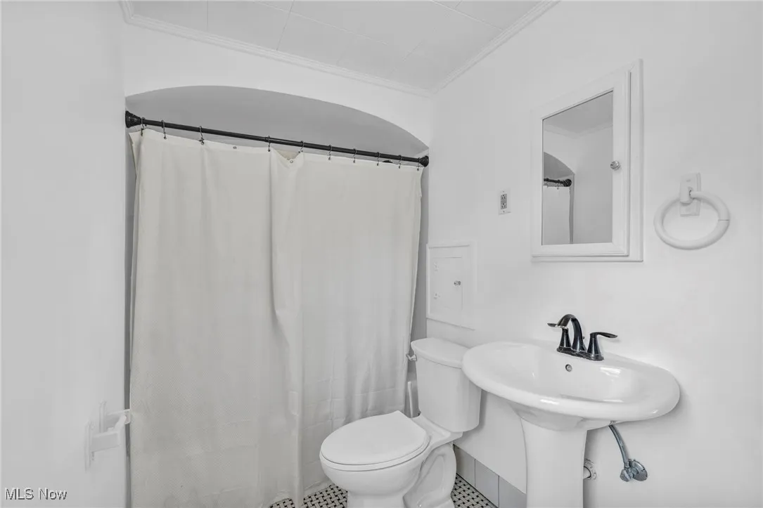 Bathroom with crown molding, tile patterned floors, and curtained shower