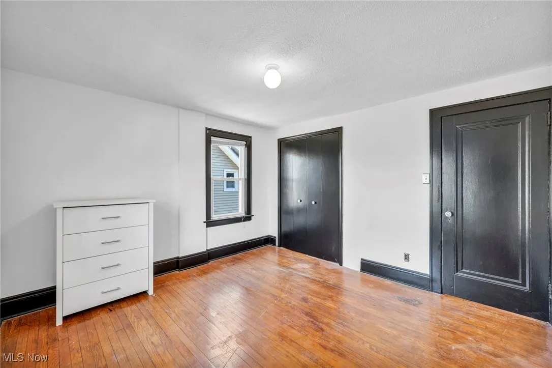 Unfurnished bedroom featuring hardwood / wood-style floors and a textured ceiling