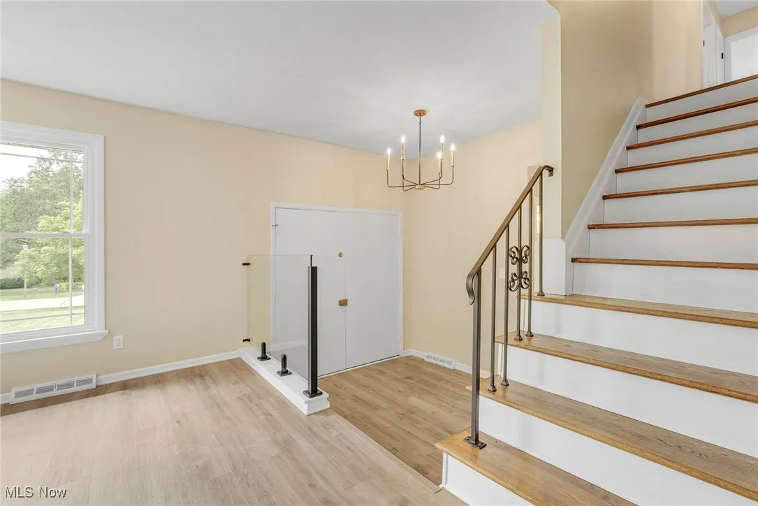 Spacious foyer accented by a modern glass railing