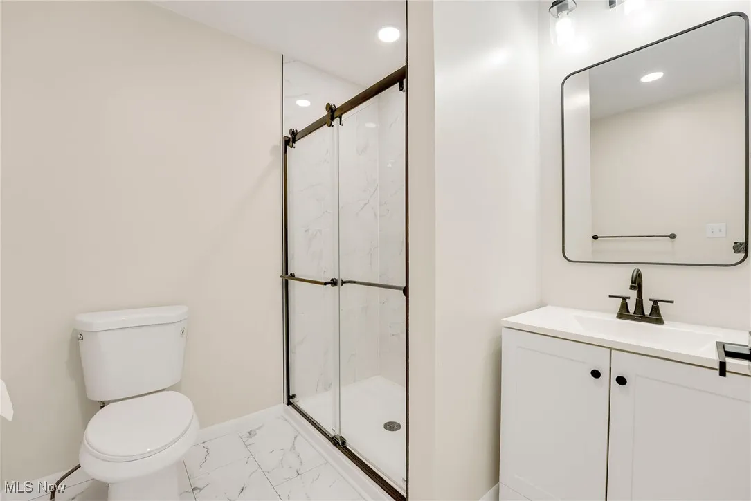 Updated primary bathroom with tiled floor and walk-in shower