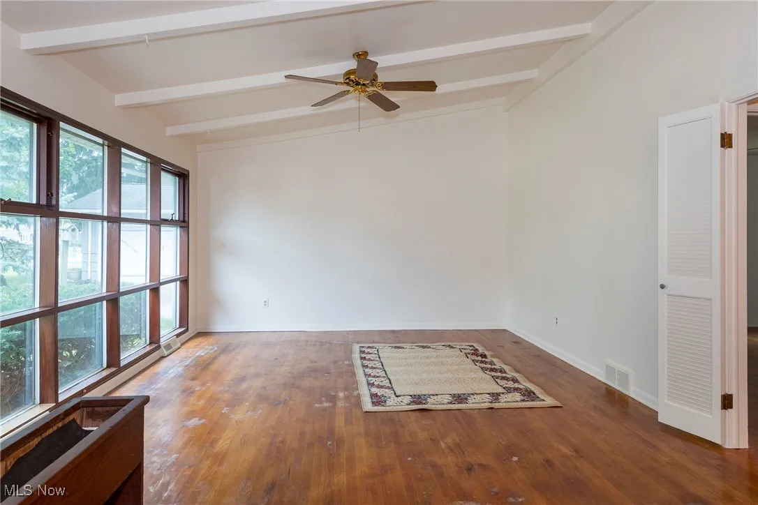 View of living room with a rug that shows you can cover stains until able to refinish floors