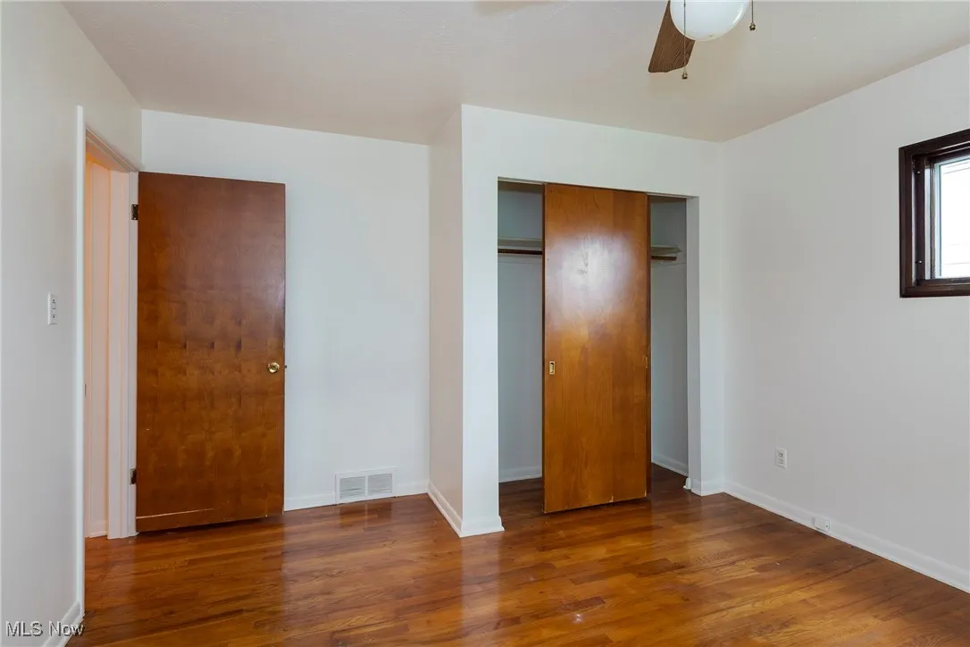 Primary Bedroom featuring hardwood floors, a ceiling fan, and a closet