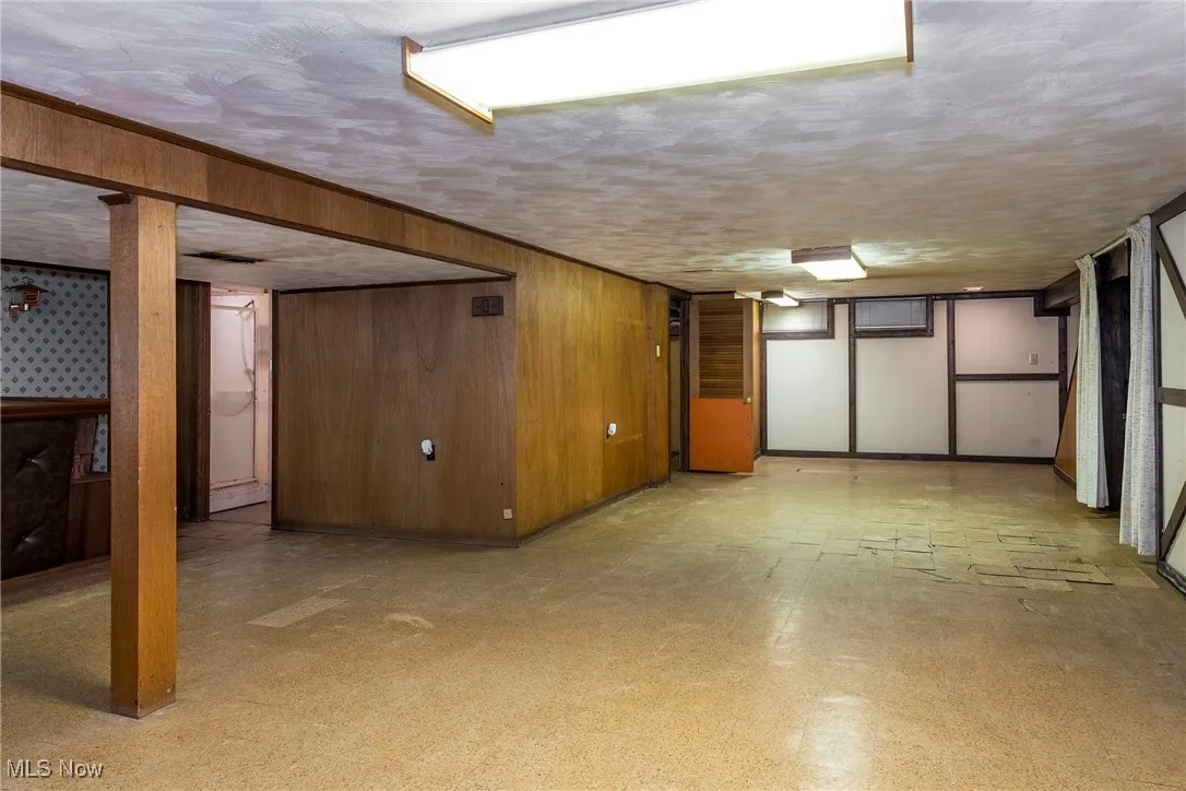 Finished basement with light flooring and wooden wall accents