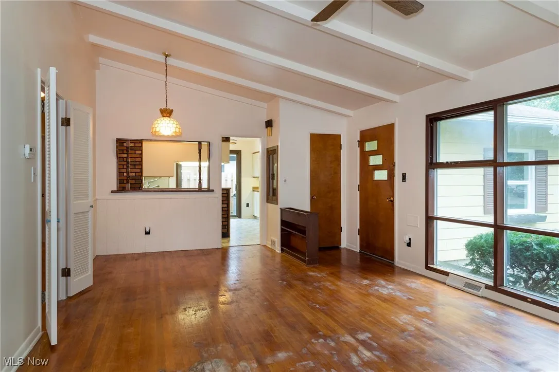 Living room/dining room combo with hardwood floors, built in cabinet and planter, lamp and ceiling fan