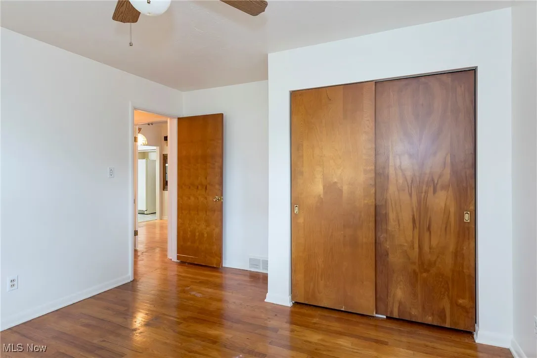 Primary Bedroom featuring hardwood floors, a closet, and a ceiling fan