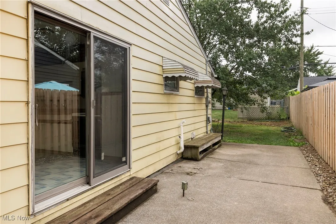 View of home's exterior with a patio area accessed from kitchen slider