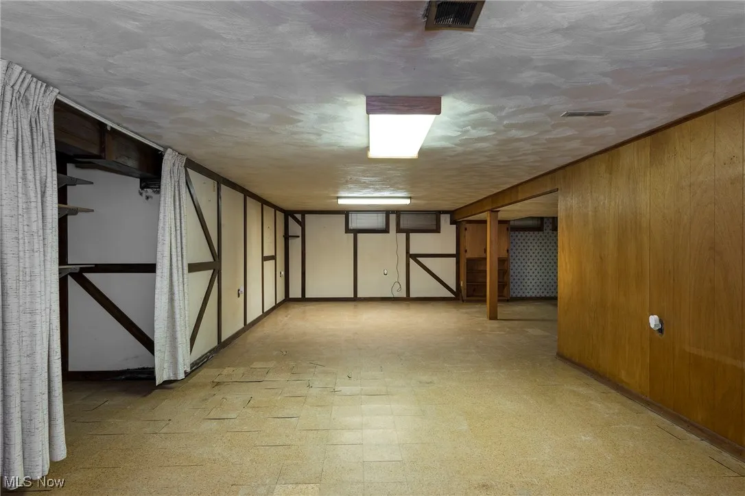 Finished below grade area featuring light flooring, wall accents and a bar