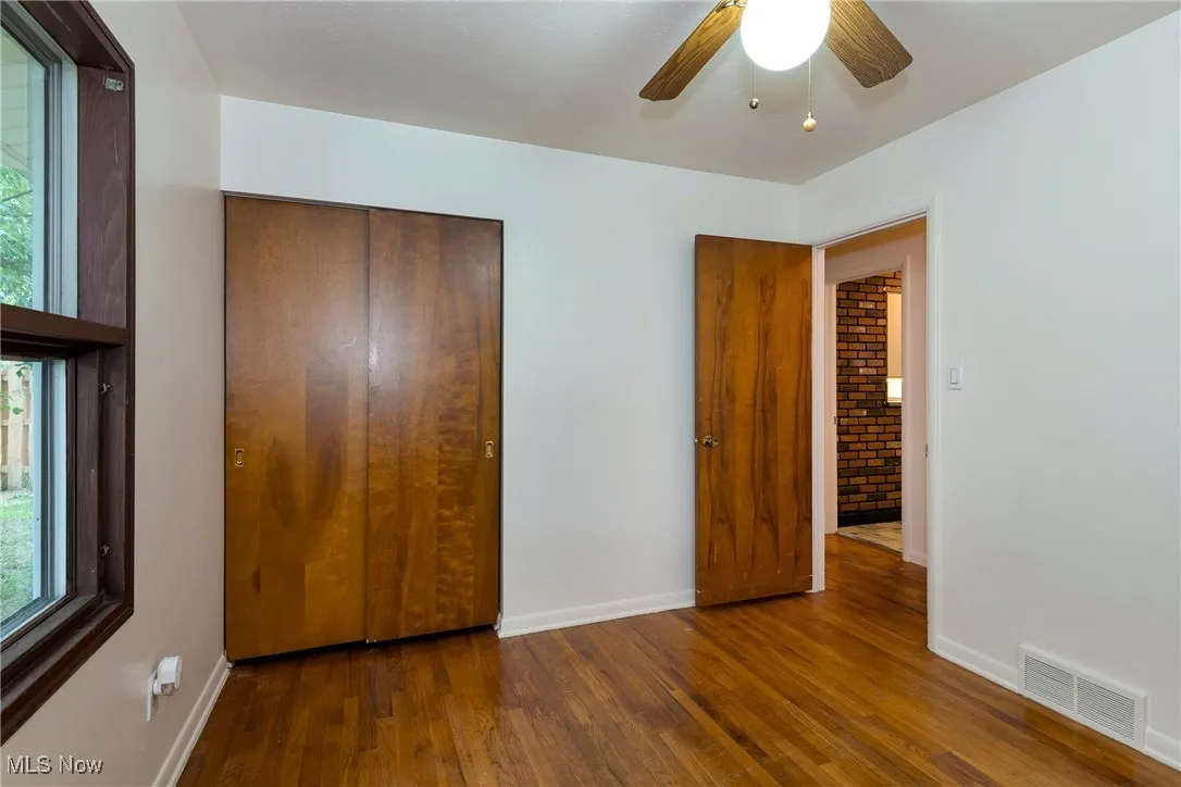 Bedroom featuring hardwood flooring, a closet, and a ceiling fan