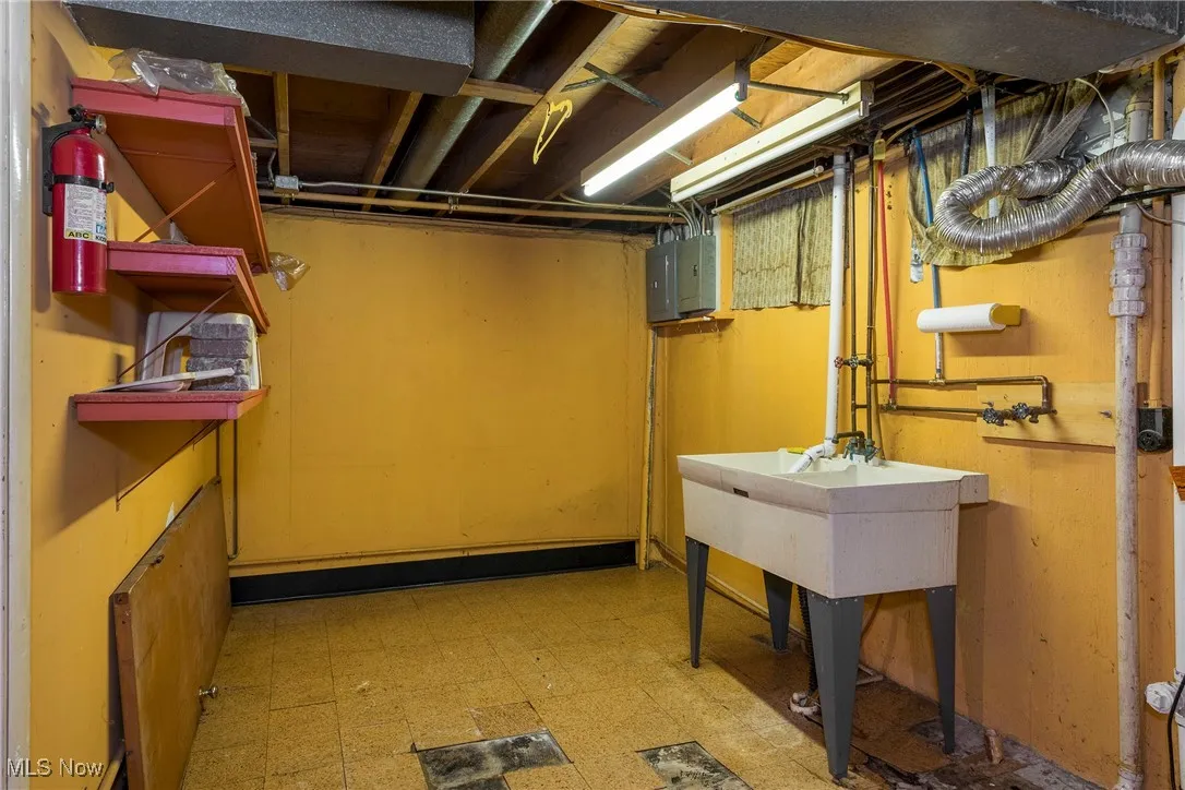 Unfinished basement featuring light floors and electric panel - could move laundry back to this room