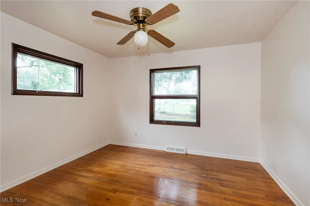 Primary Bedroom featuring hardwood flooring, plenty of natural light, and a ceiling fan