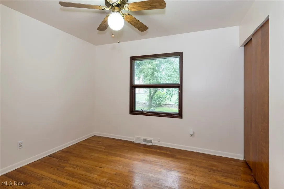 Bedroom with hardwood flooring and a ceiling fan