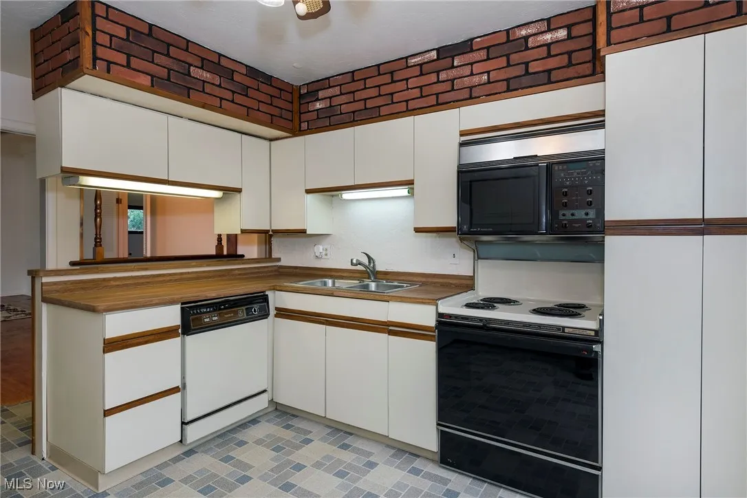 Kitchen featuring white cabinets, electric range, white dishwasher, and microwave