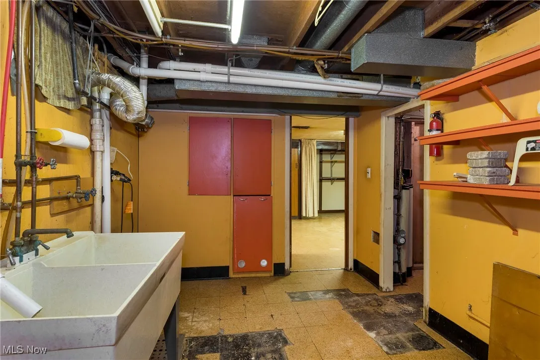 Unfinished basement featuring light floors and a sink - could move laundry back to this area