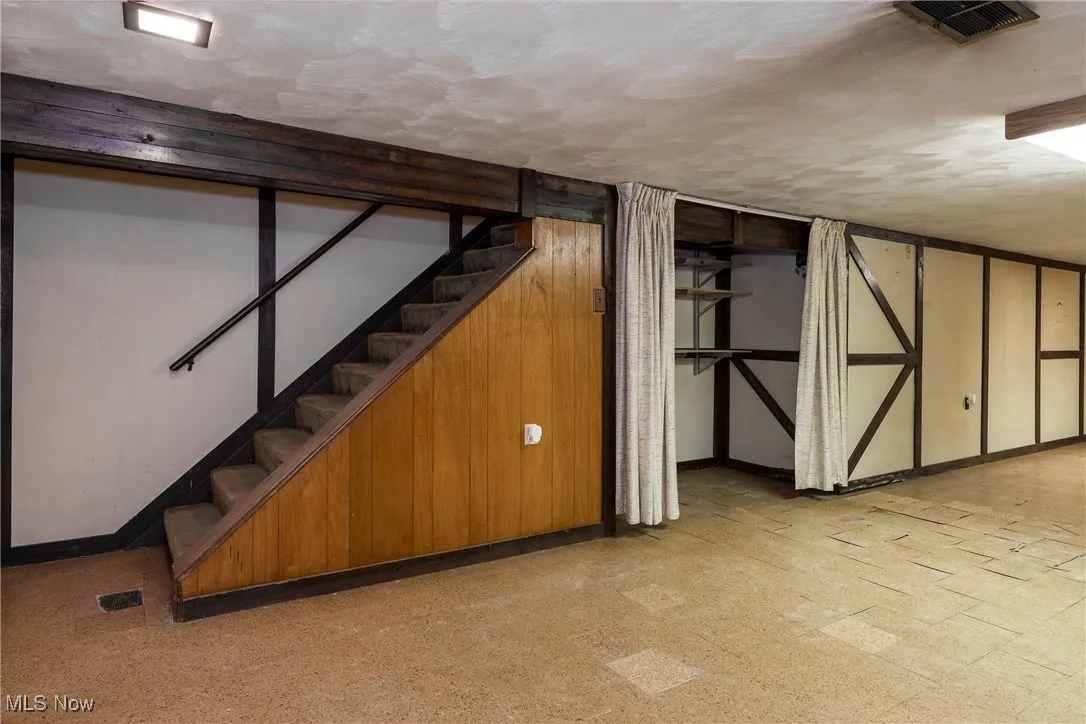 Finished basement with light floors and stairs