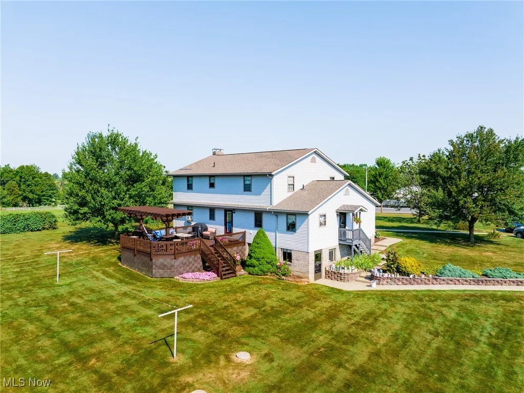 Back of property with stairs, a yard, a deck, a patio, and a pergola