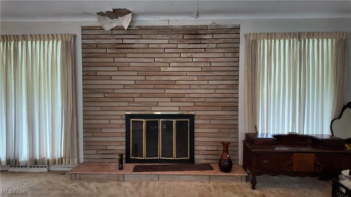 Detailed view of carpet flooring and a brick fireplace