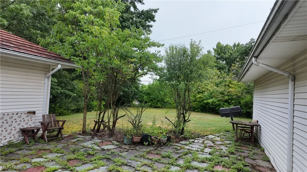 View of grassy yard with a patio area