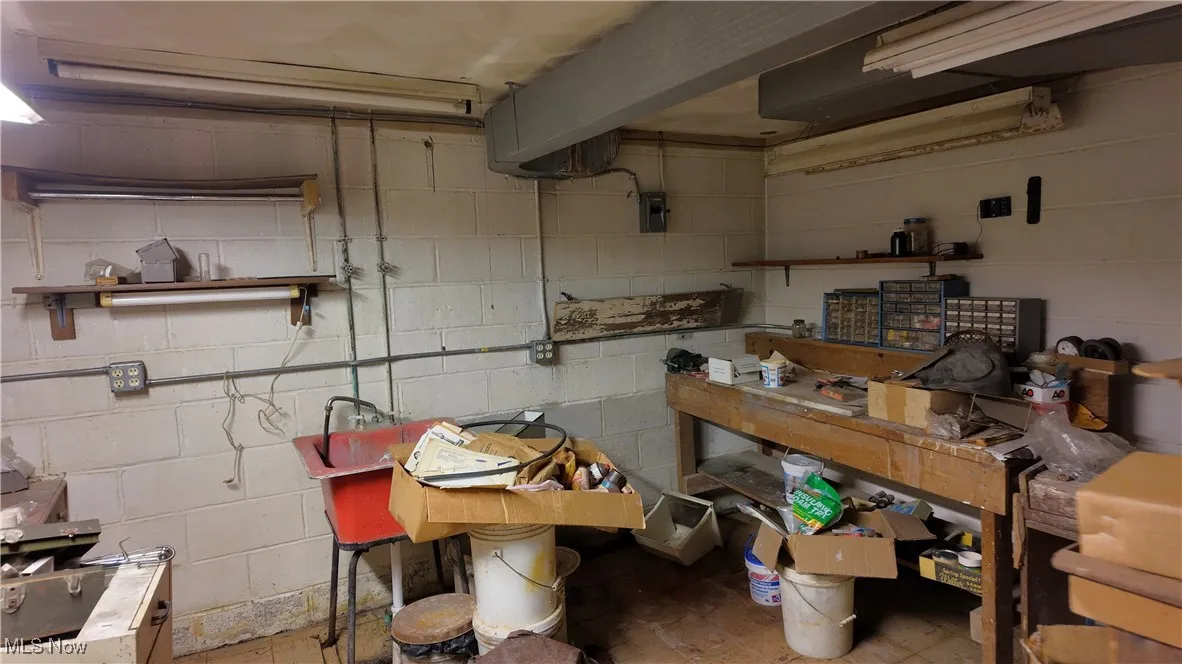 Kitchen featuring open shelves and concrete block wall
