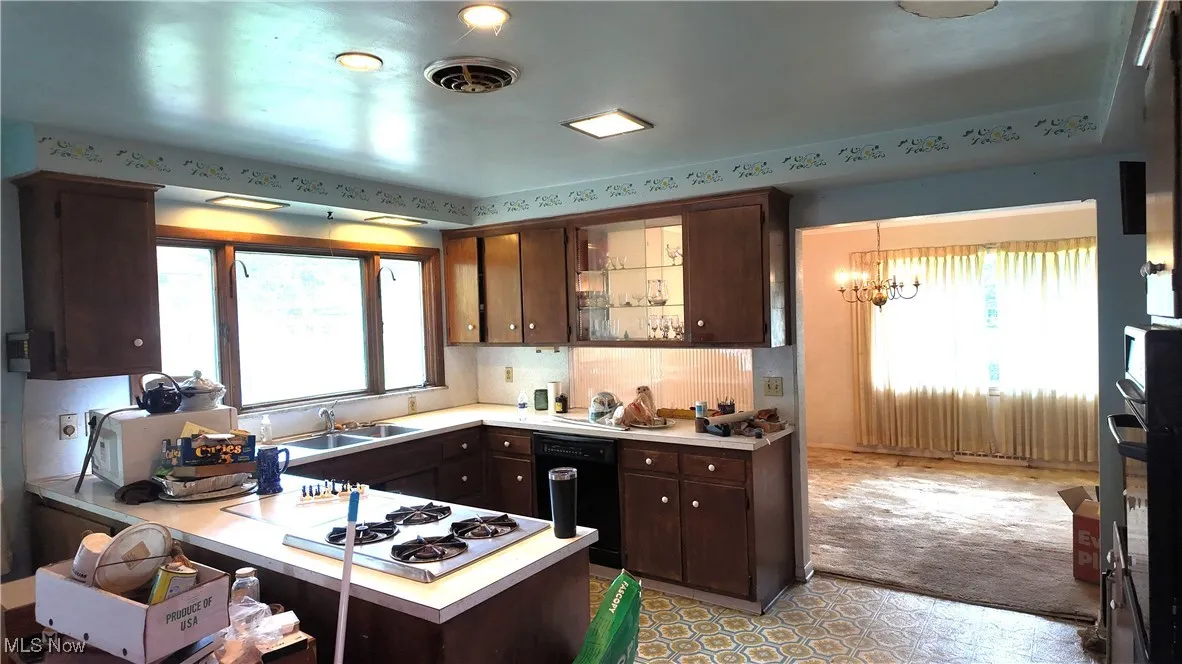 Kitchen with dark brown cabinetry and light countertops