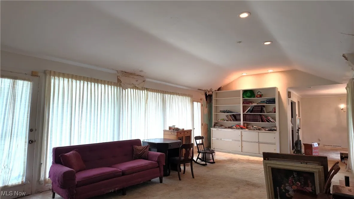 Living area with lofted ceiling, carpet, and recessed lighting