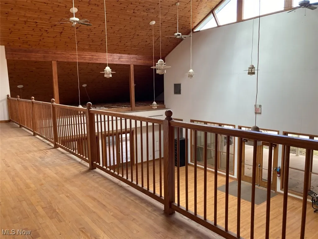 Hall featuring wooden ceiling, light wood-style flooring, and high vaulted ceiling