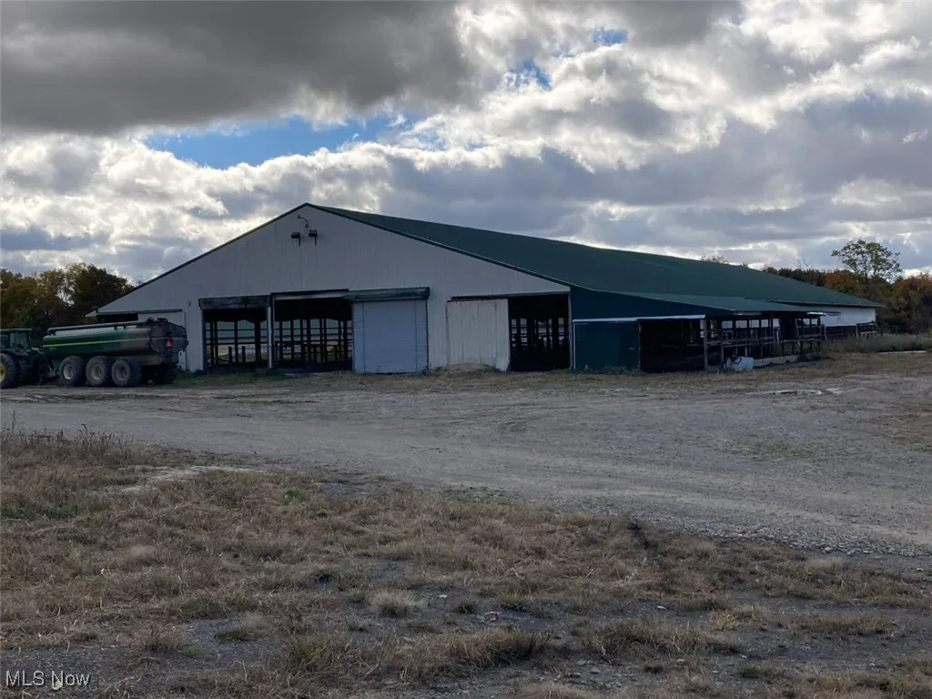 View of pole building featuring dirt driveway